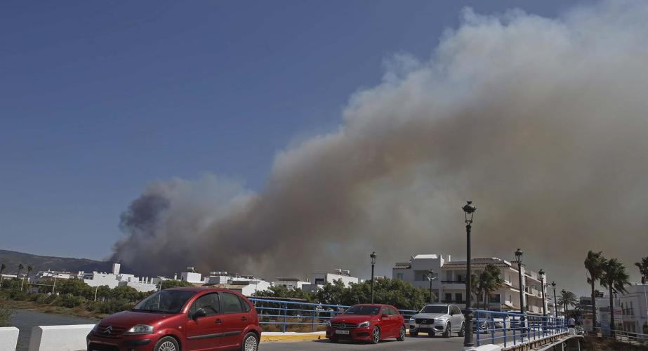 Varios vehículos salen de Atlanterra y Zahara de los Atunes bajo el humo del siniestro