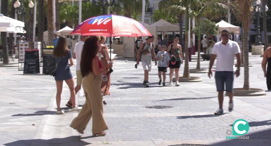 Una mujer se protege del sol en la plaza de San Juan de Dios
