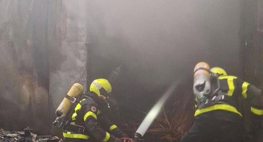 Dos bomberos actuando en el incendio en una fábrica de conservas de Tarifa.