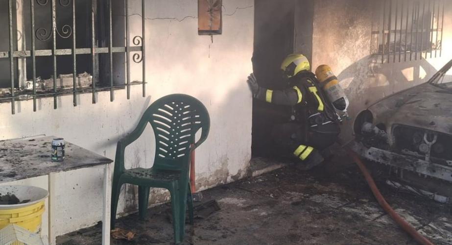 Un bombero actuando en la entrada del inmueble donde se produjo el siniestro