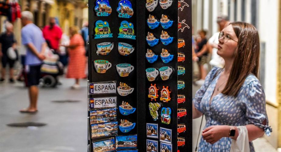 Una persona mirando una tienda de recuerdos tuísticos de Cádiz