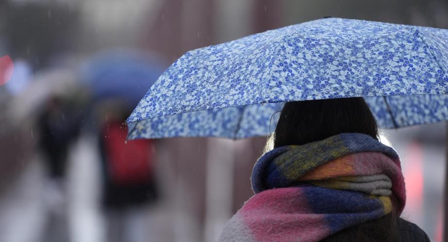 Una persona se protege de la lluvia con un paraguas