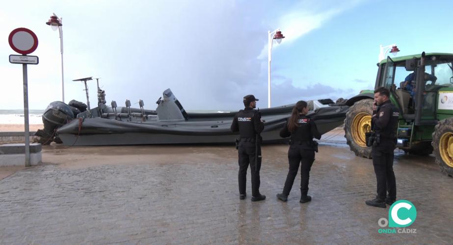Agentes junto a la embarcación en su retirada en el paseo marítimo de la capital gaditana