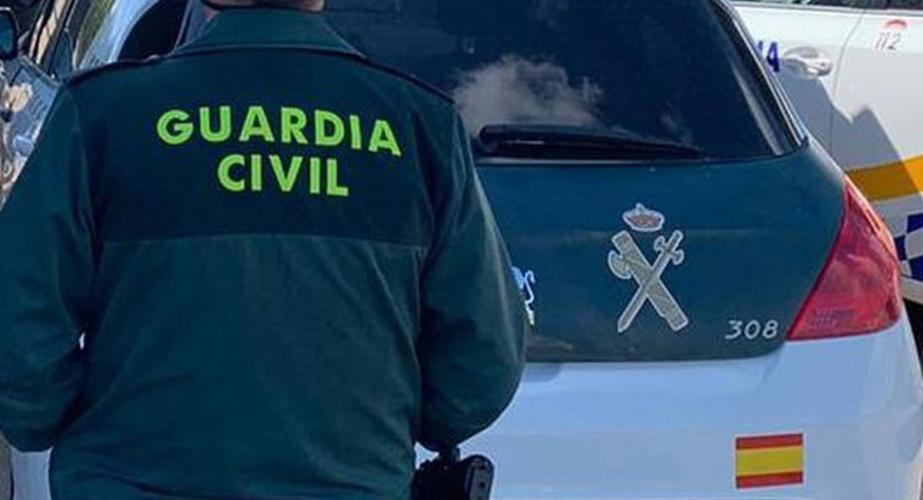 Un agente de la Guardia Civil junto a un vehículo oficial.