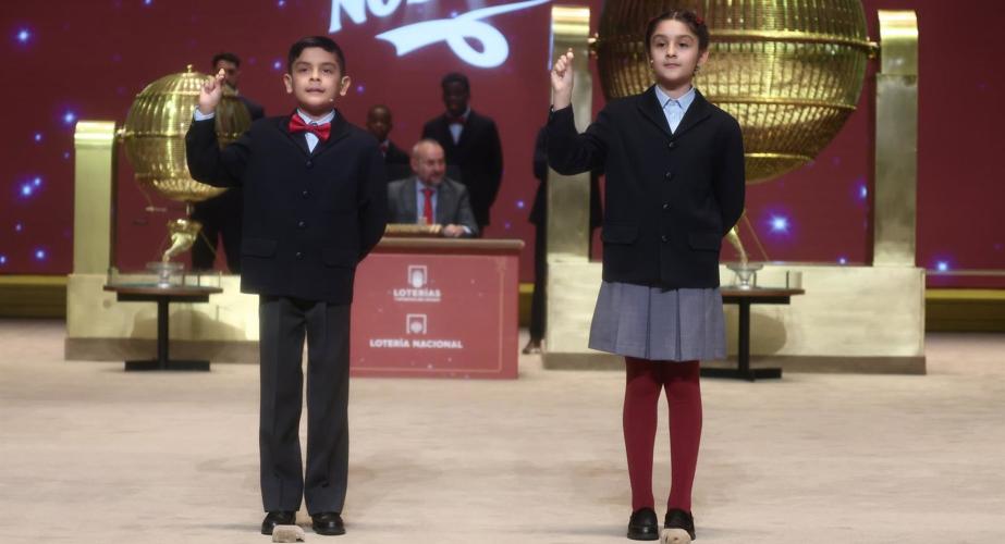 Dos niños del Colegio de San Ildefonso, cantan el tercer premio durante el sorteo