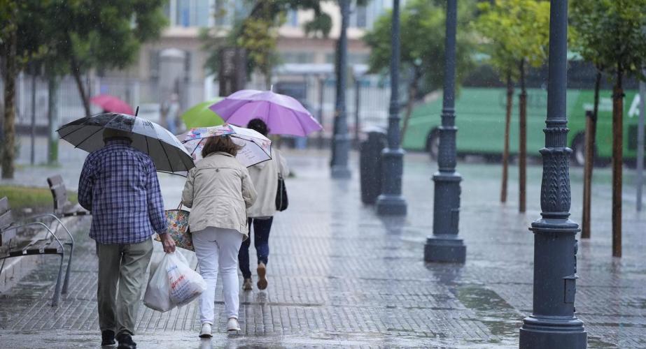 Transeúntes bajo sus paraguas durante una intensa lluvia en Cádiz.