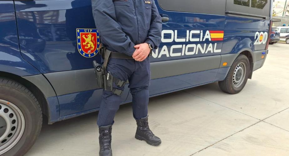 Imagen de archivo de un coche y un agente de la Policía Nacional