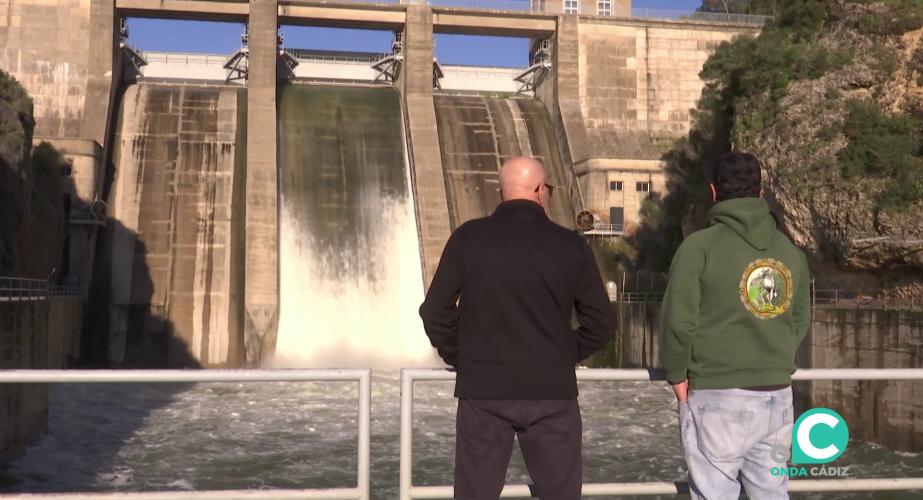 Dos personas observan la caida de agua de los Hurones