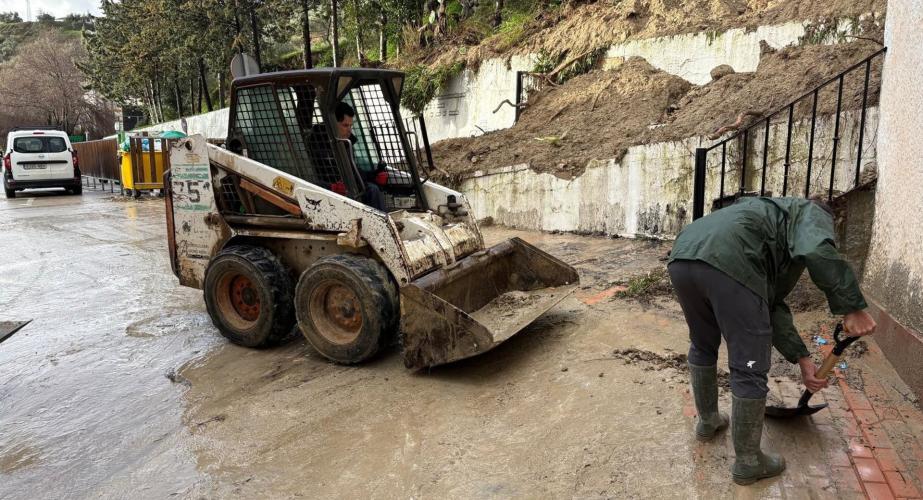 Operarios de Alcalá del Valle trabajan en una calle sobre los efectos del temporal de lluvia.