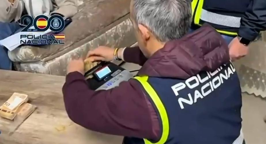 Un agente cuenta dinero intervenido a una organización dedicada al tráfico de armas para el narcotráfico.