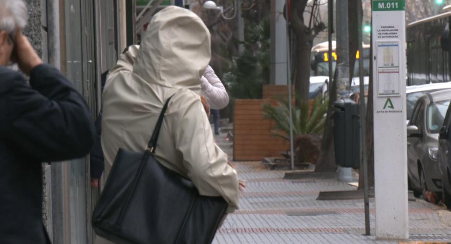 Viandantes dse protegen del viento y la lluvia en la capital gaditana