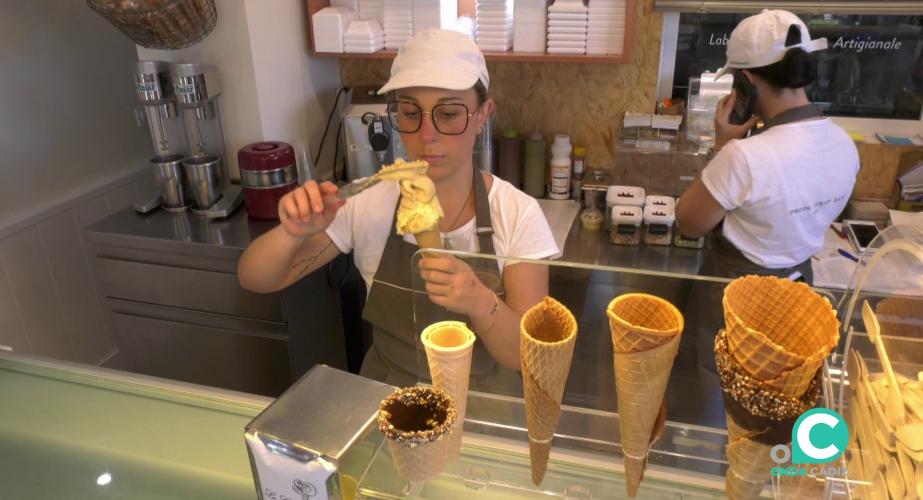 Una empleada del establecimiento prepara uno los productos para ser servidos a los clientes 