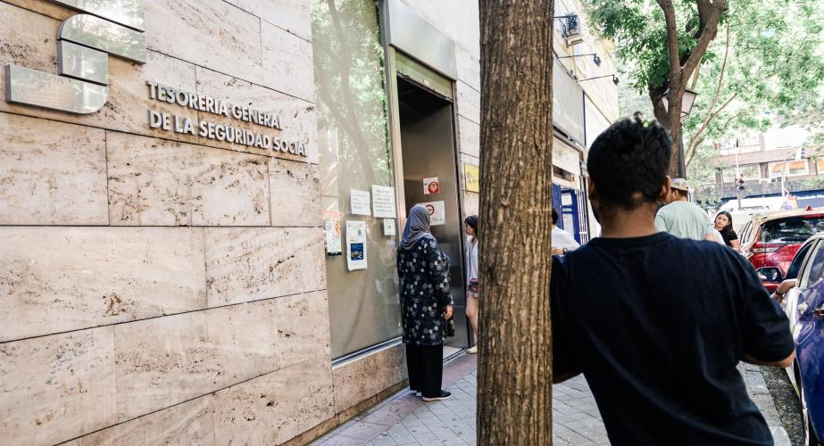 Varias personas esperan en el exterior de una oficina de la Seguridad Social, en el marco de la regularización extraordinaria de migrantes