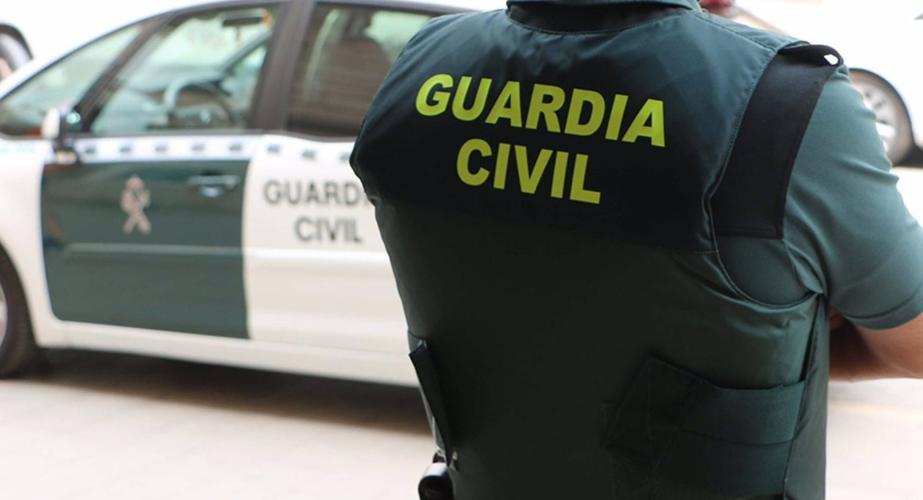 Un agente de la Guardia Civil junto a un vehículo oficial