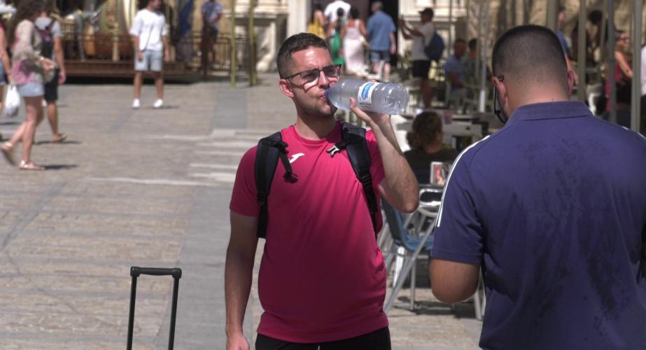 Un viandante se hidrata en la plaza de la Catedral de la capital gaditana