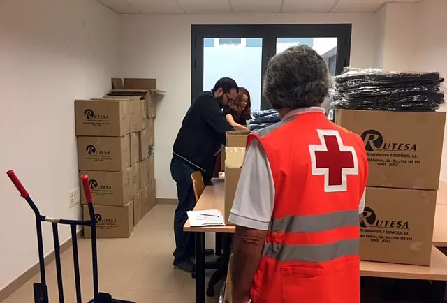 Miembros de Cruz Roja almacenan ropa de otra campaña