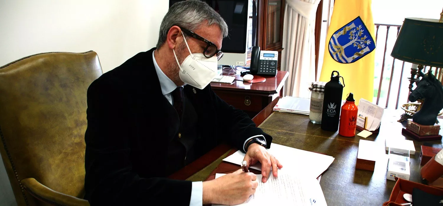 El rector firmando el convenio de colaboración