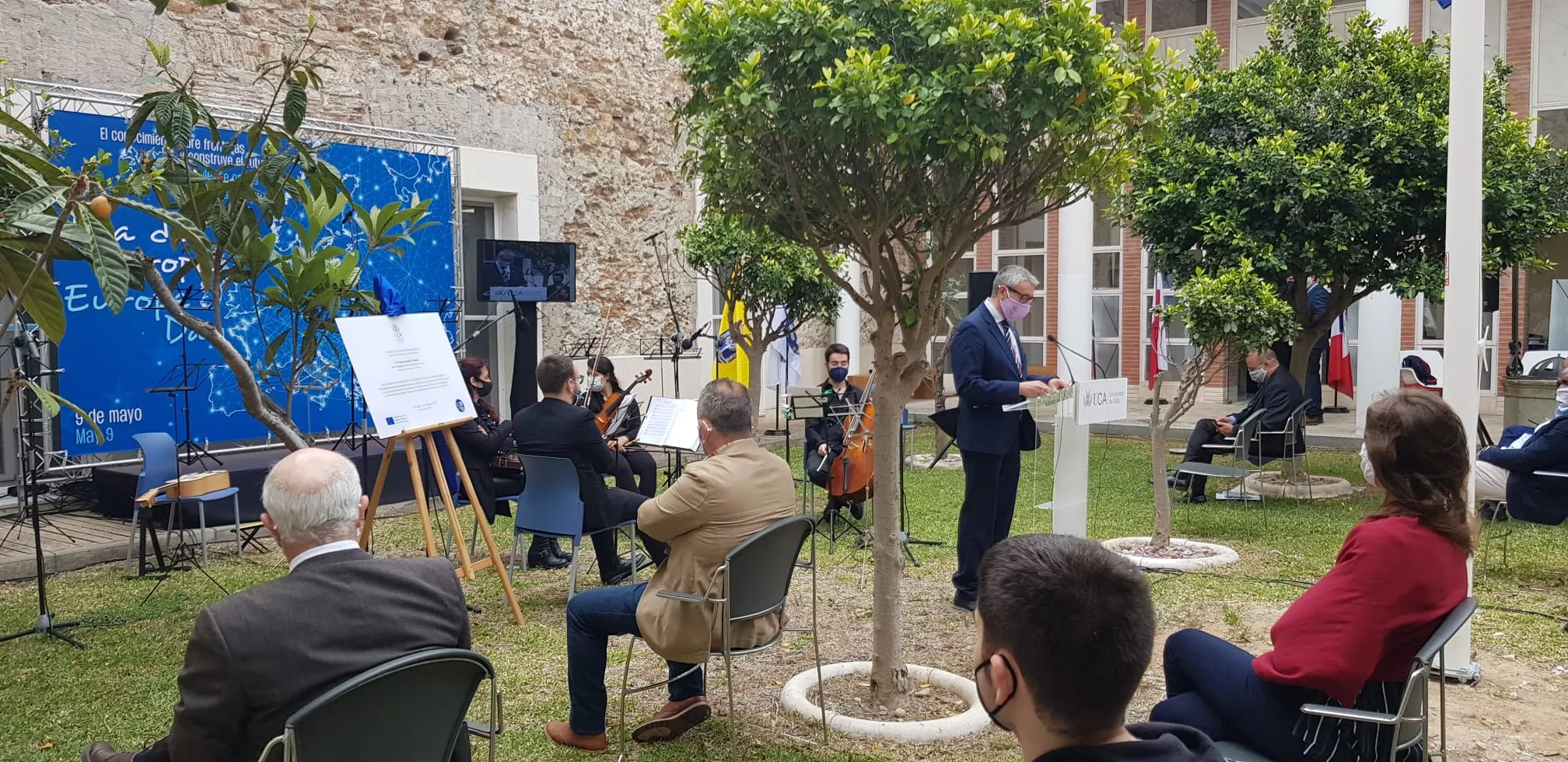 El edificio Hospital Real, sede del vicerrectorado de Internacionalización, acoge un acto conmemorativo con izada de bandera europea y descubrimiento de placa en la inauguración del Patio de las Naciones