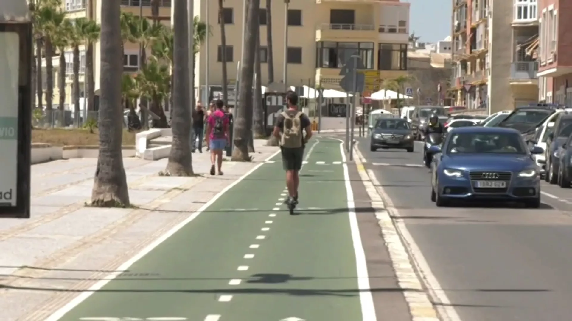 Joven circula en patinete en el carril bici