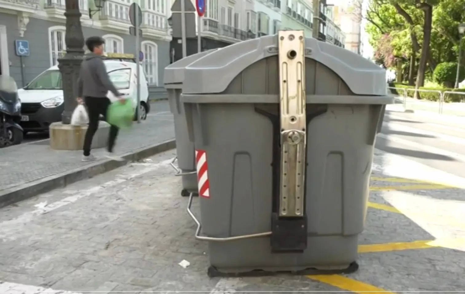 Un ciudadano deposita basura en un contenedor del casco antiguo de Cádiz