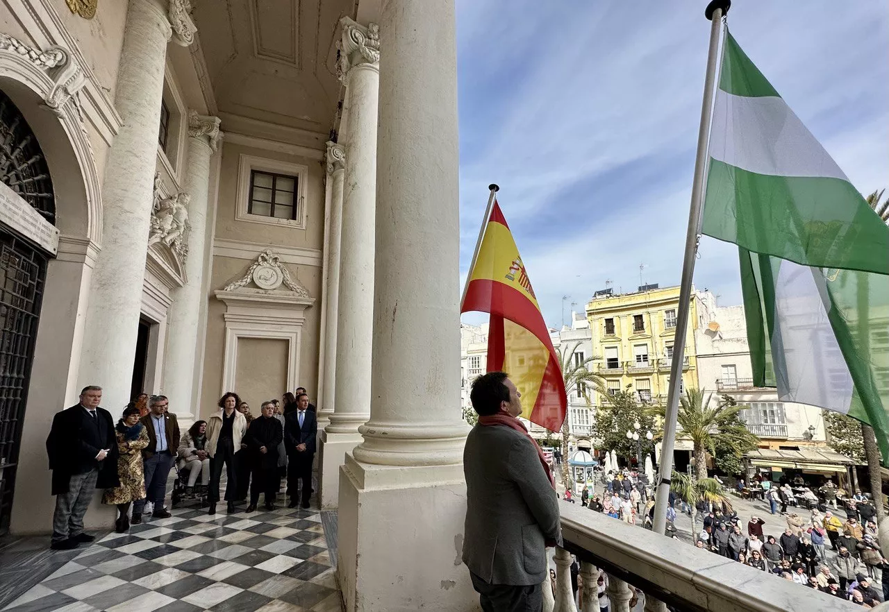 El acalde de Cádiz, junto a miembros de la Corporación municipal, durante la interpretación del himno de Andalucía en el balcón del Ayuntamiento