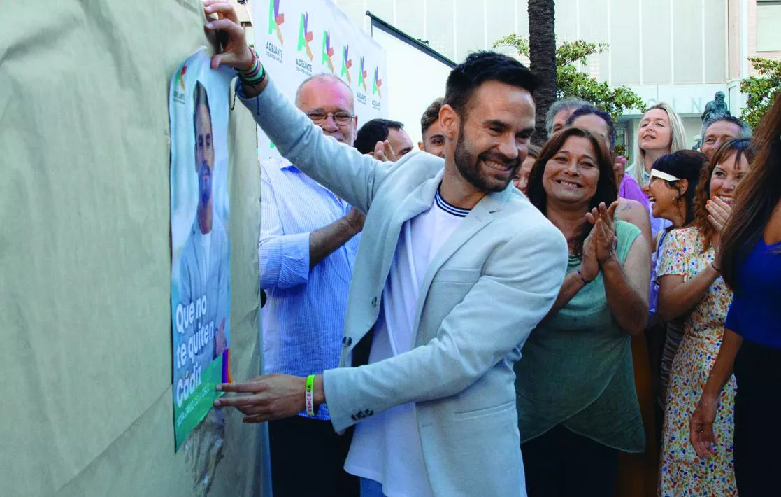 El candidato David de la Cruz durante la pegada de carteles