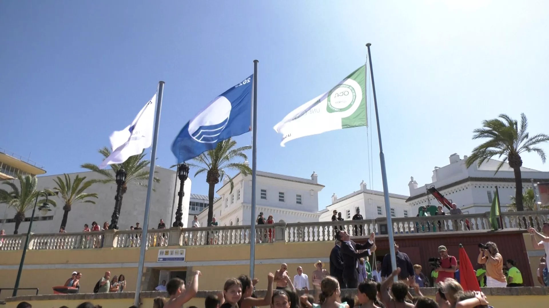Momento en el que el alcalde, Bruno García, ha izado las banderas en La Caleta 