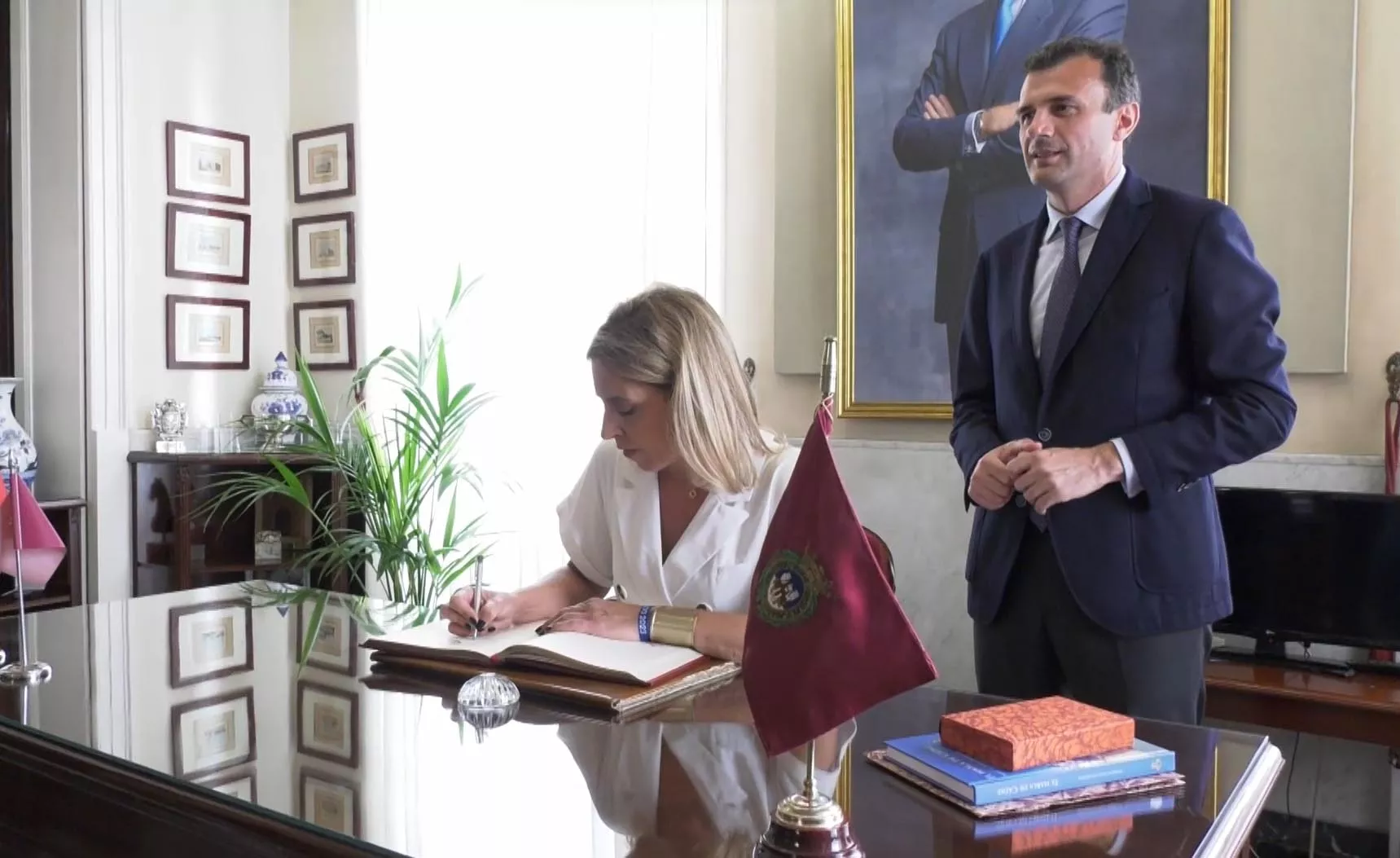 La presidenta de Diputación, Almudena Martínez del Junco, firmando en el libro de Honor del Ayuntamiento de Cádiz ante la presencia del alcalde Bruno García en su primera visita institucional al consistorio 