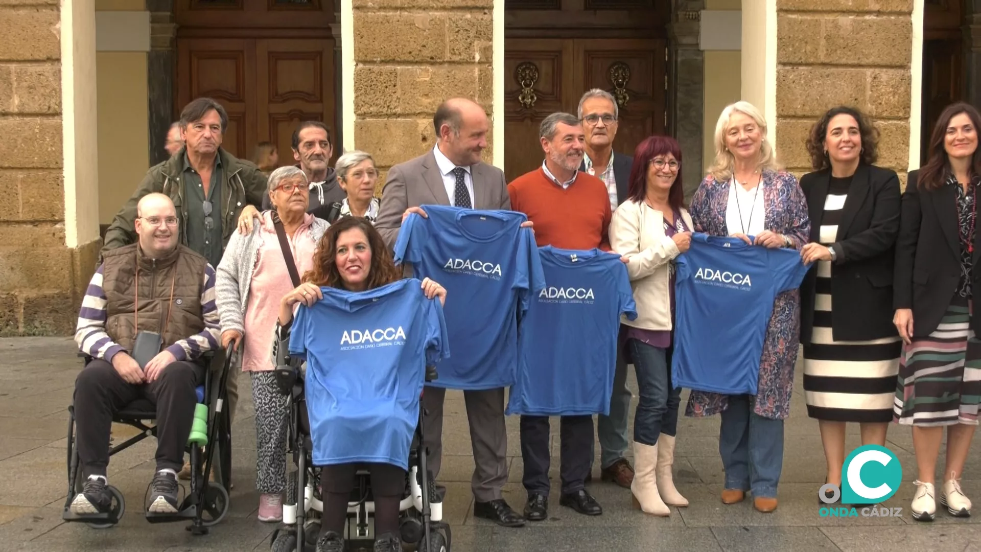 Foto de familia en la plaza de San Juan de Dios de algunos miembros de ADACCA con parte del equipo de gobierno del Ayuntamiento.