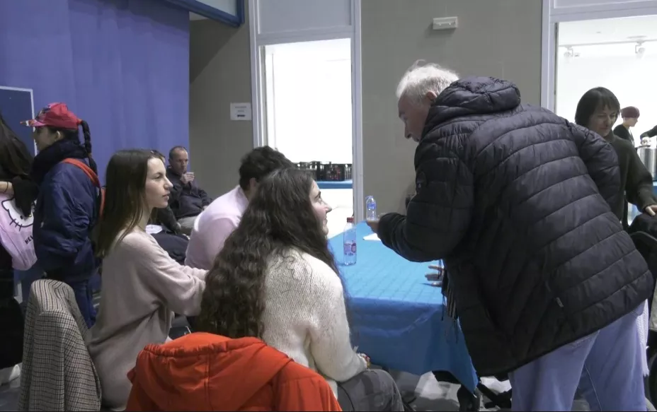 Jovenes y mayores se reúnen en una merienda intergeneracional.