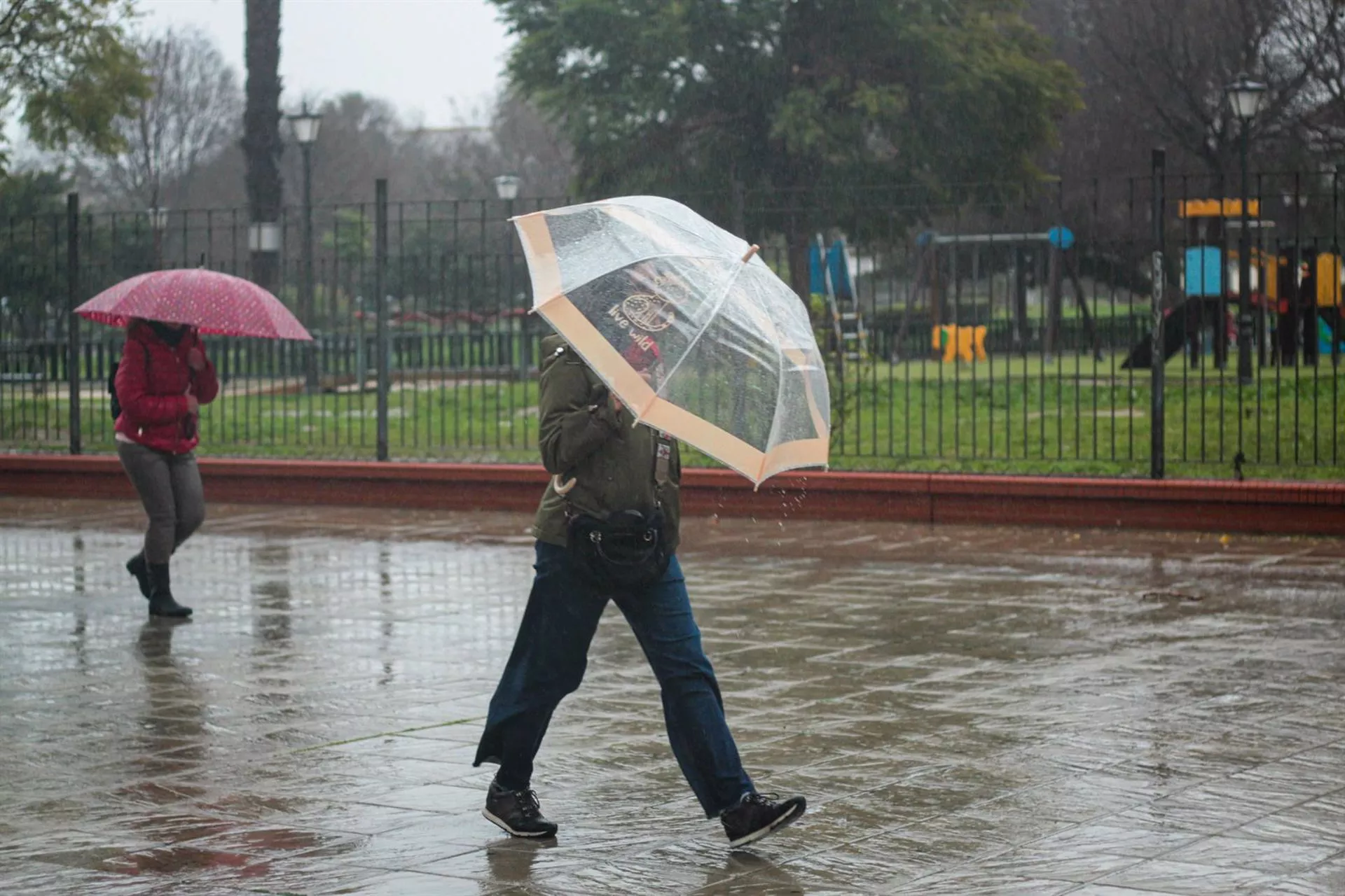 Unos transeúntes se protegen de la lluvia.