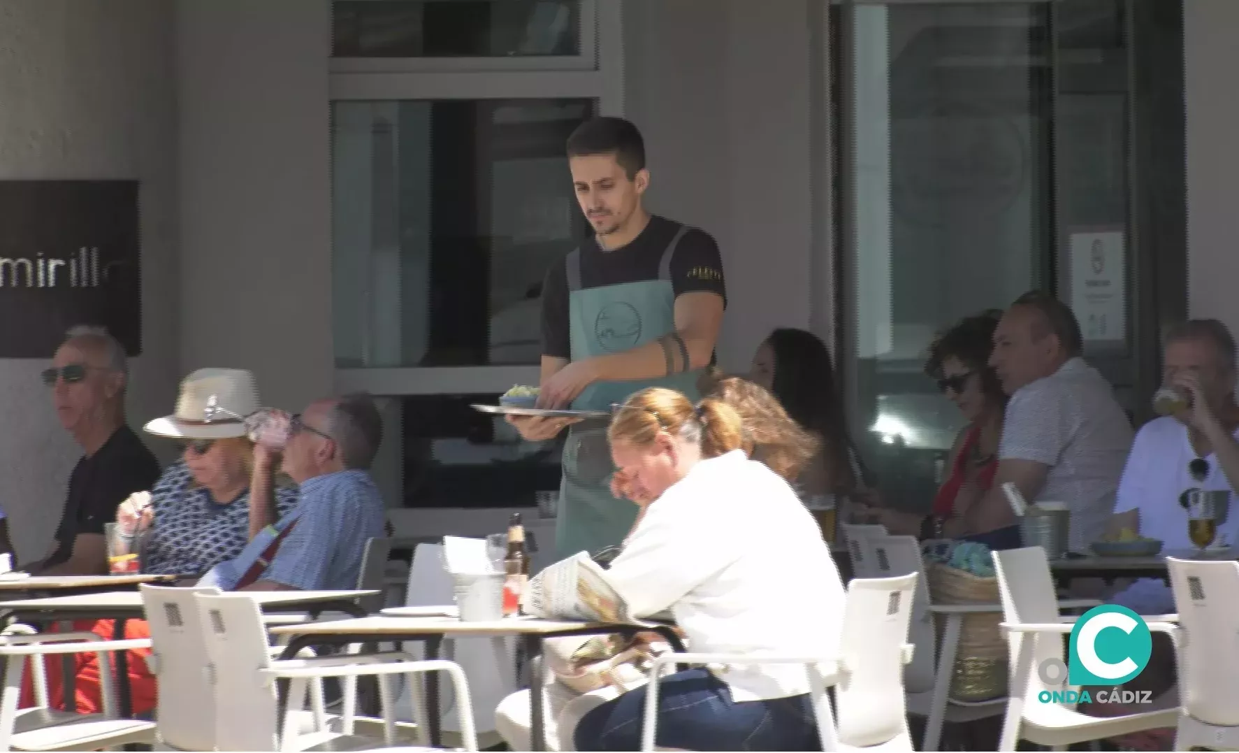 Un camarero sirve una mesa en una terraza de Cádiz. 