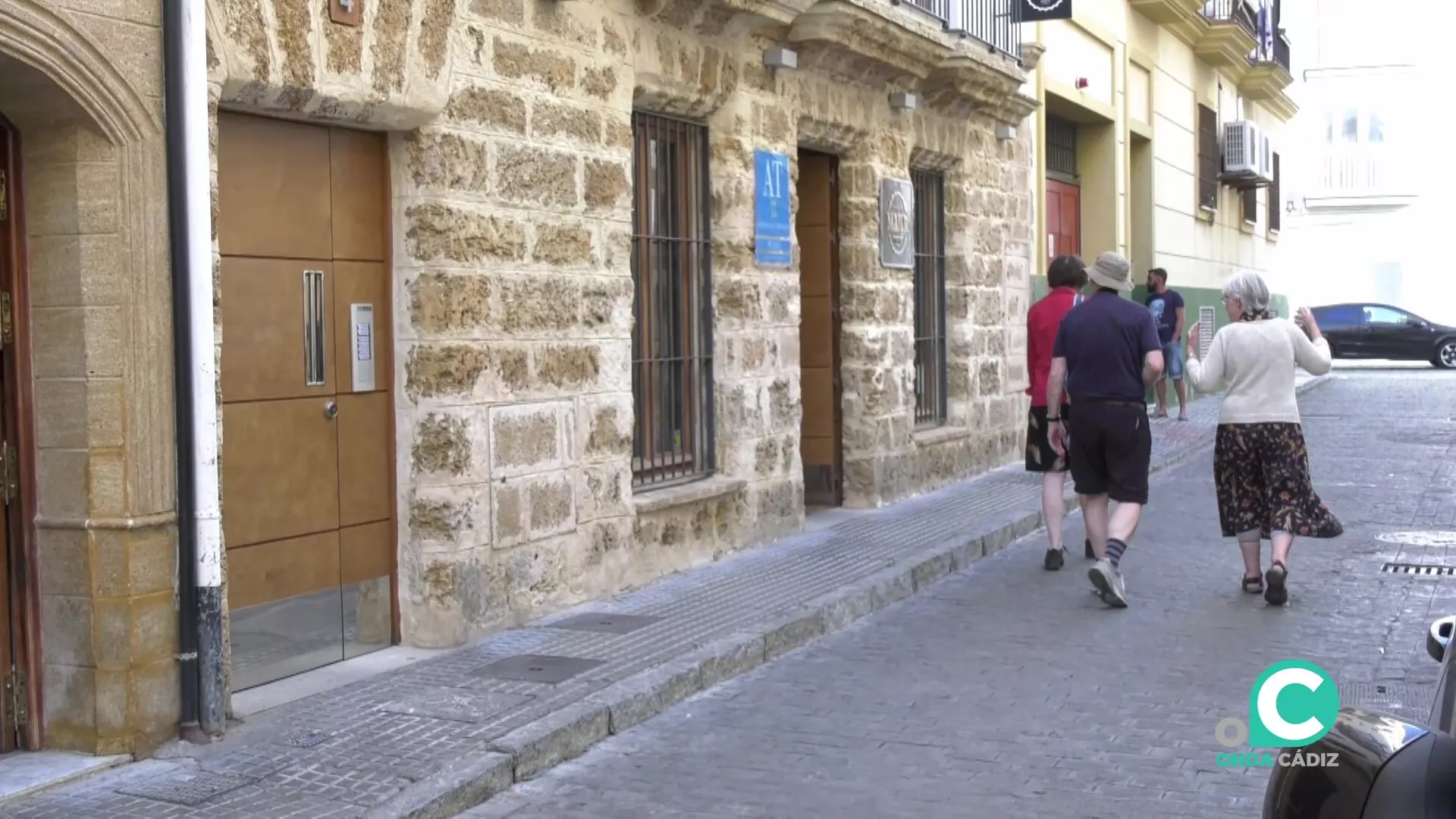 Turistas junto a un edificio de alojamiento hostelero en el centro de Cádiz