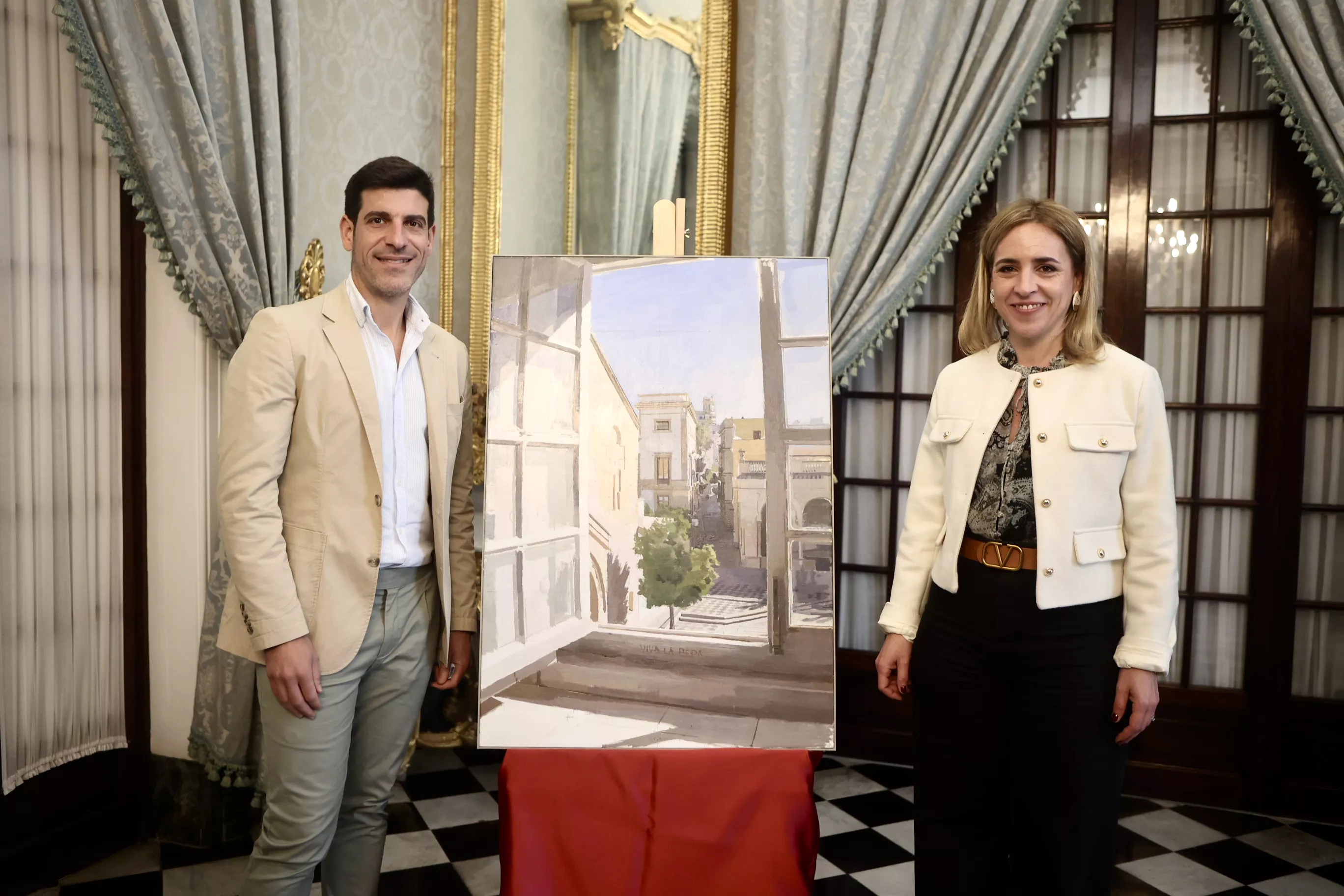 La presidenta de la Diputación, Almudena Martínez, y el pintor Eduardo Millán junto a la obra del autor jerezano