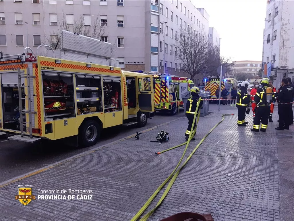 Una dotación de bomberos trabaja en la extinción del incendio en un piso de la calle Grazalema de la ciudad. 