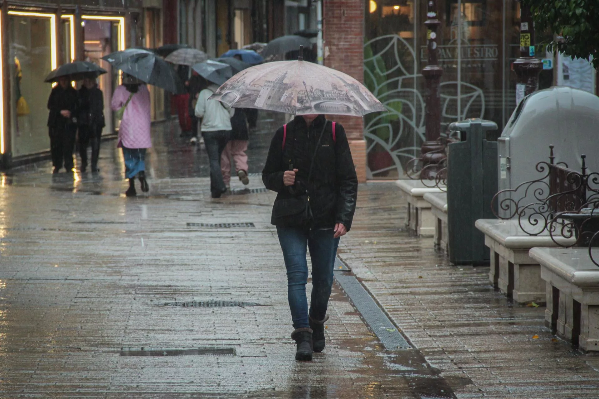 Varias personas se protegen de la lluvia bajo sus paraguas