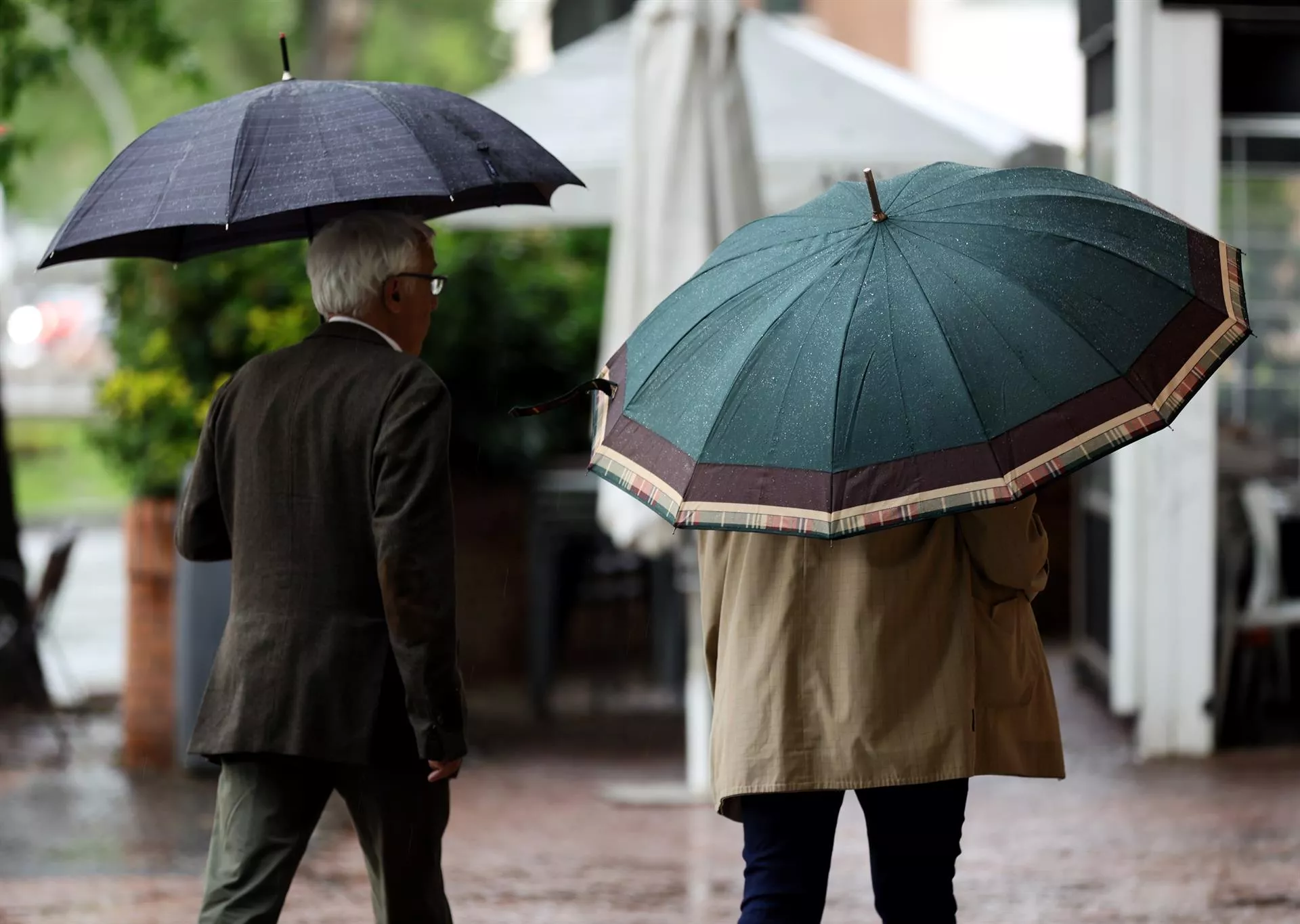 Dos viandantes se protegen de las fuertes lluvias en una imagen de archivo