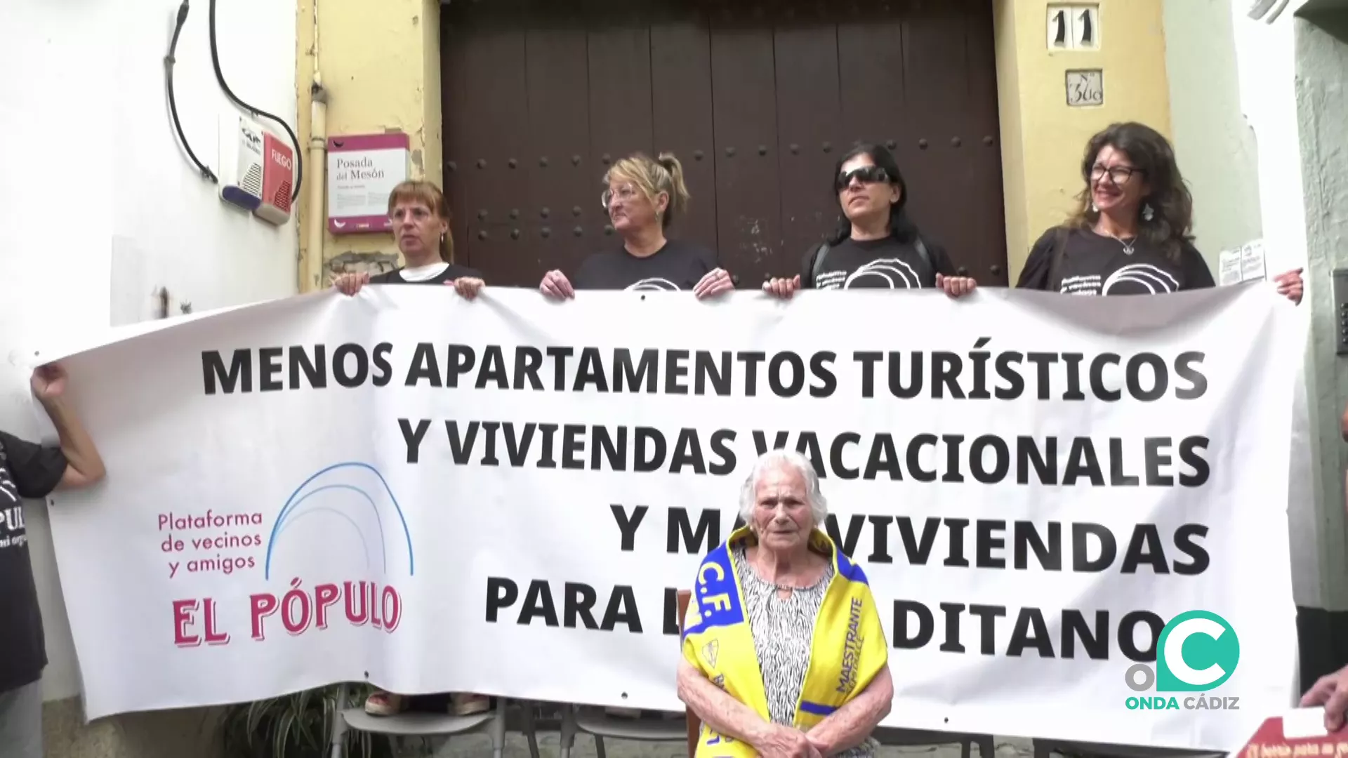 María, la vecina salvada del desahucio de su casa junto a la pancarta de la protesta