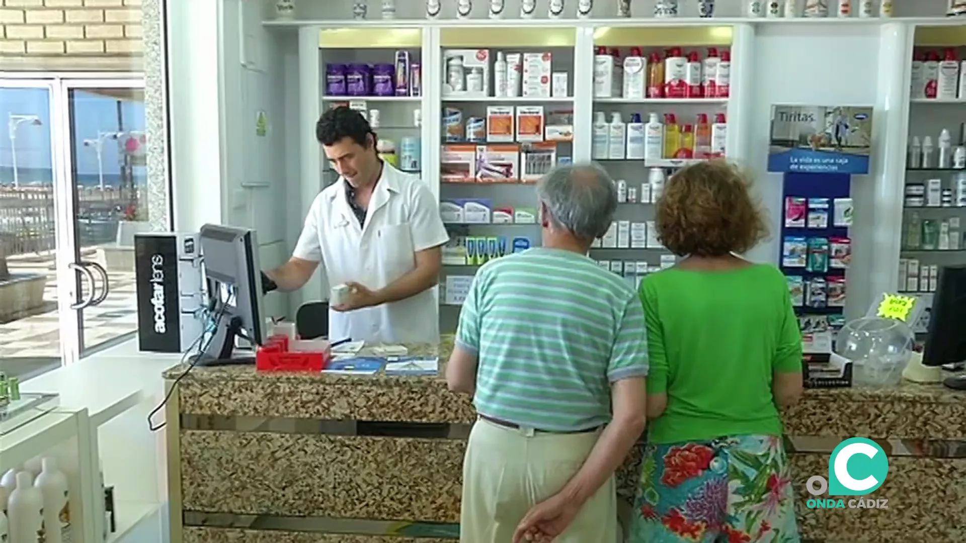 Un farmaceutico atiende a unos clientes en una botica de Cádz