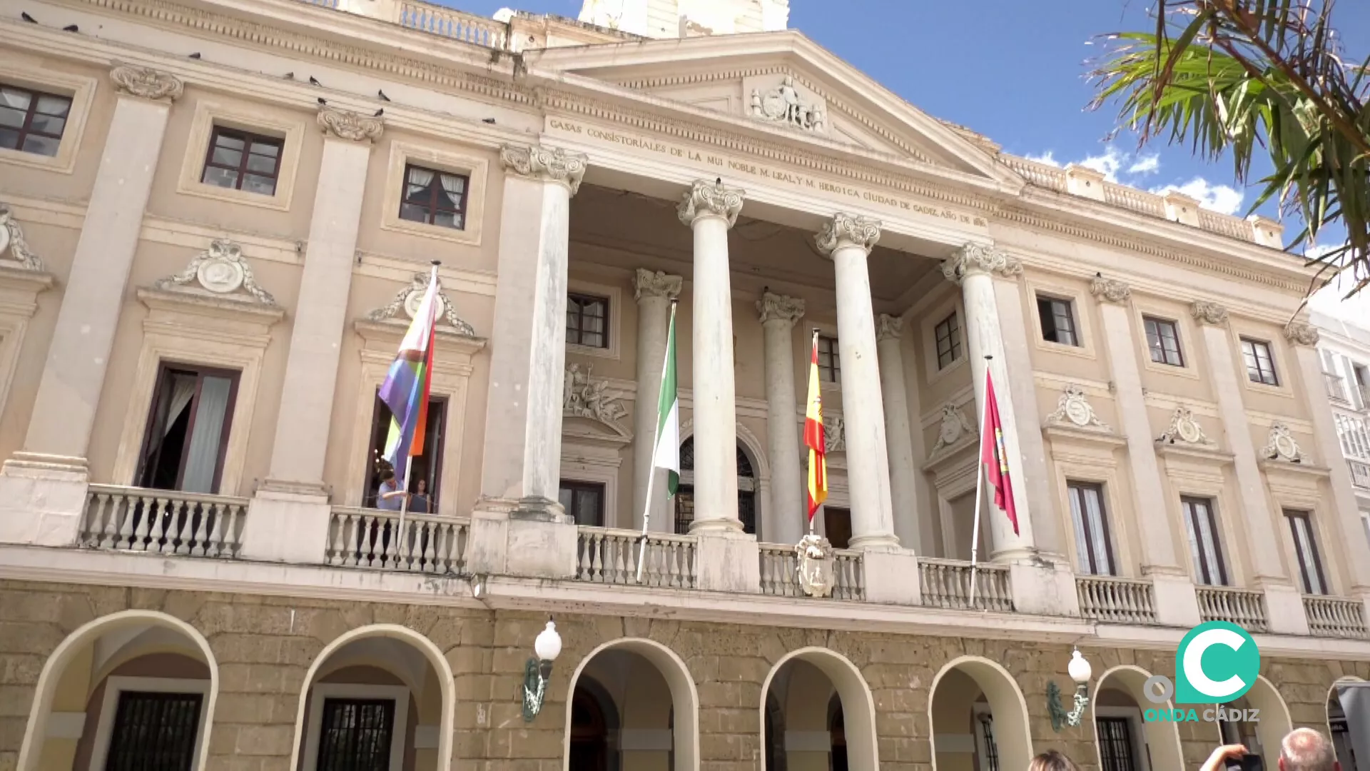 La fachada del Ayuntamiento con las respectivas enseñas oficiales ondeando junto con la bandera multicolor 