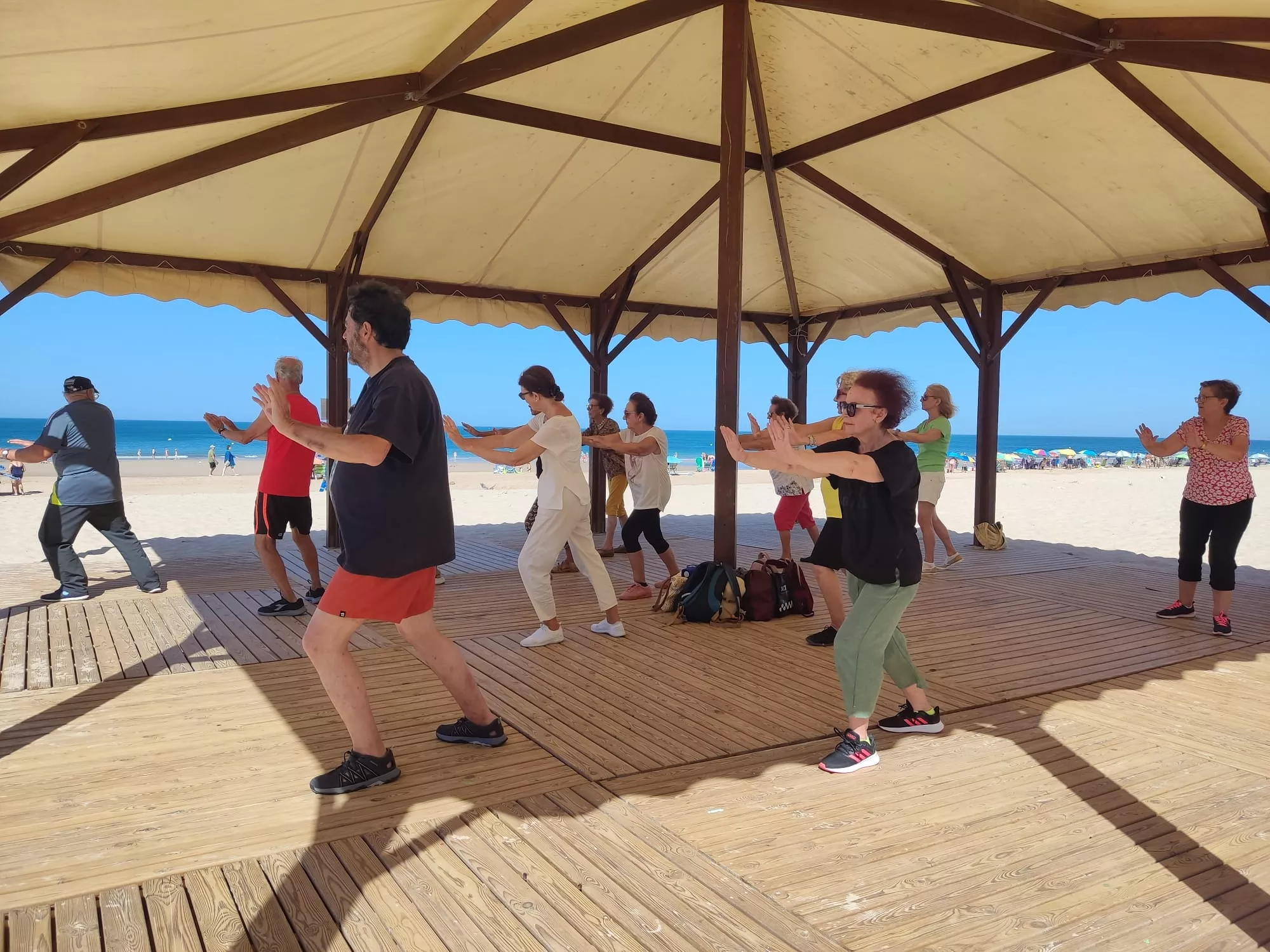 Taller de taichi en la playa para personas mayores en el Módulo Malibú de la Playa de la Victoria.