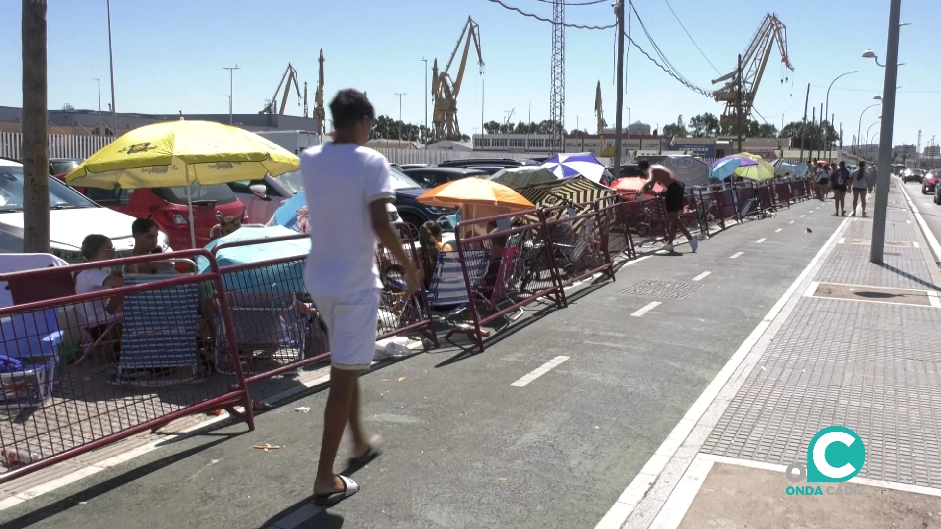 Centenares de jóvenes esperan la apertura de puertas del recinto con sillas y sombrillas