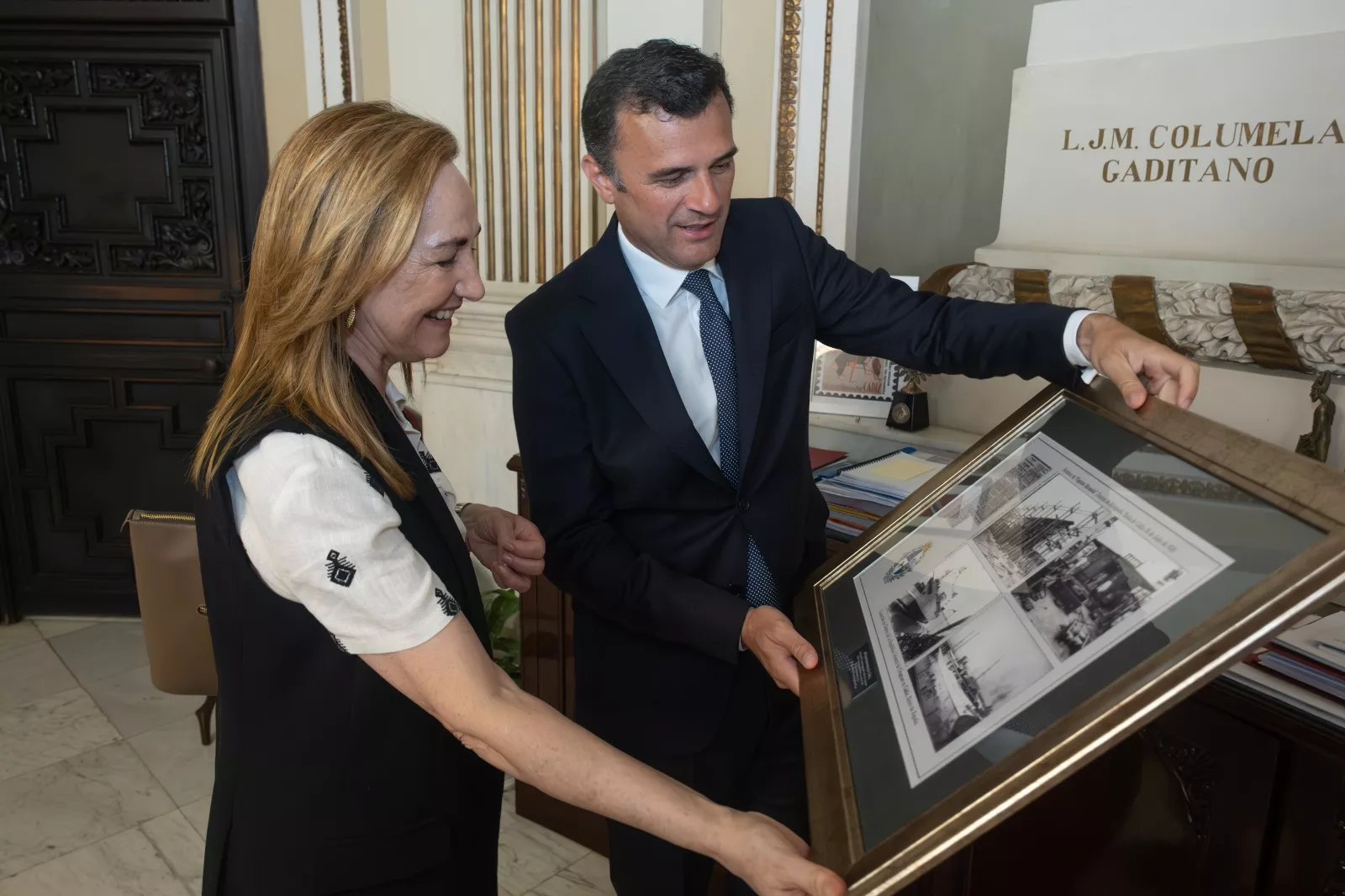 El alcalde de Cádiz muestra imágenes antiguas del puerto de Cádiz a la embajadora de Uruguay en España.