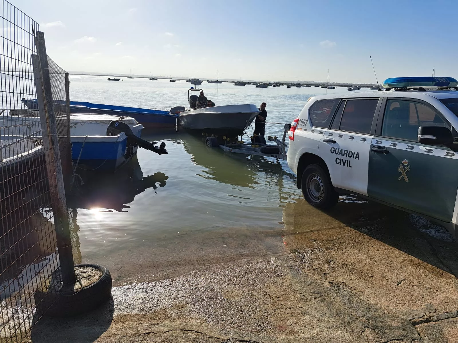 Un vehículo de la Guardia Civil saca del agua una de las embarcaciones