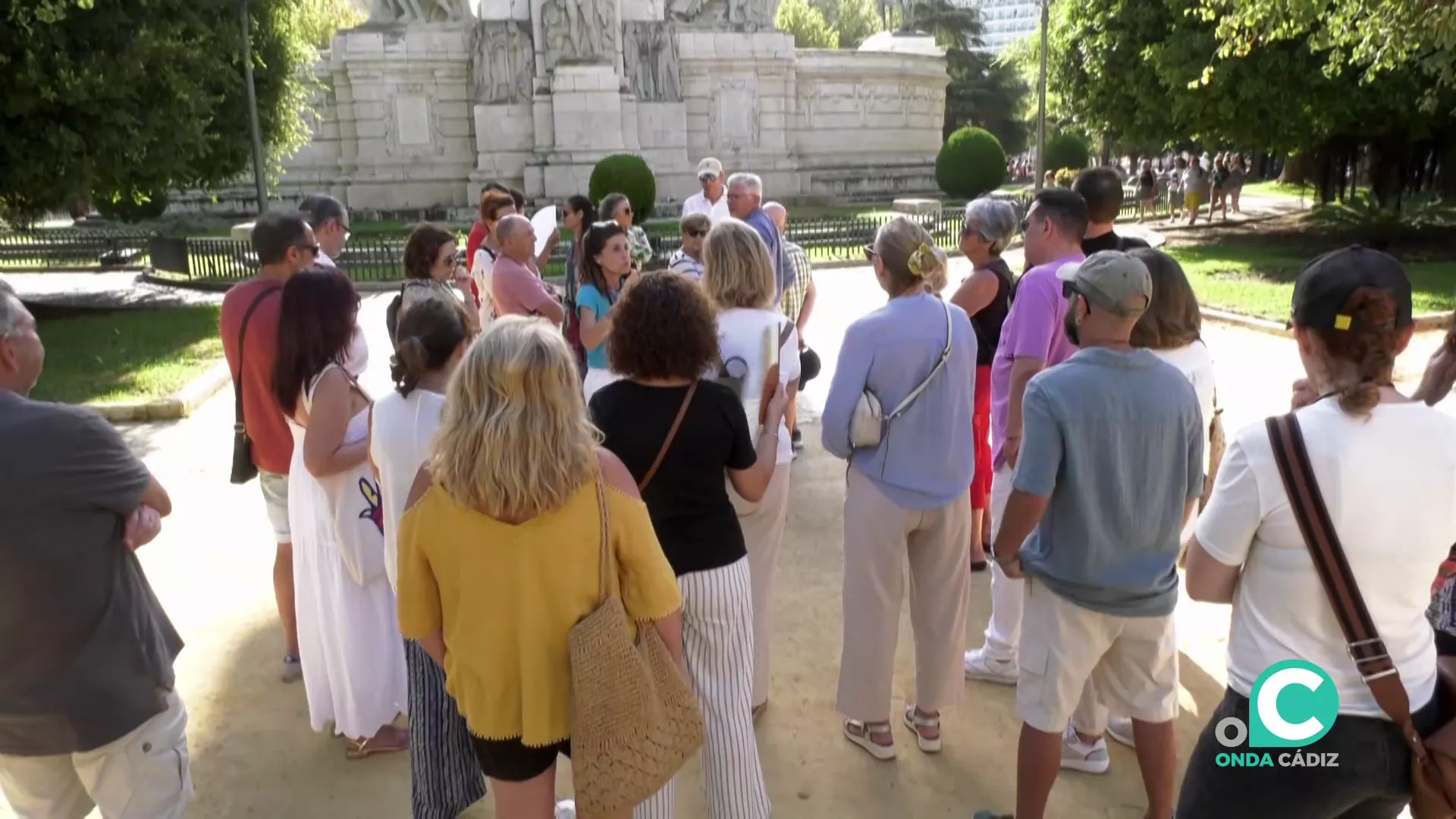 Un grupo de invitados a la singular experiencia ante el monumento de las Cortes en la plaza de España.