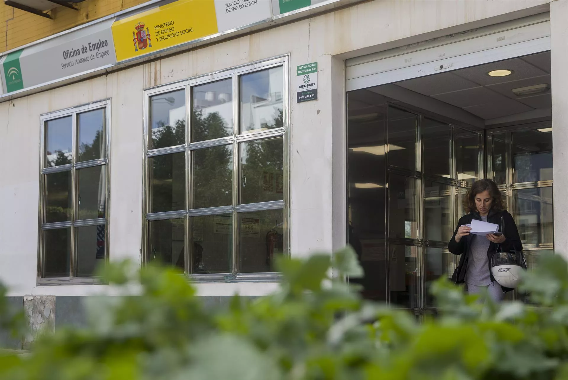 Una mujer sale de una oficina de empleo