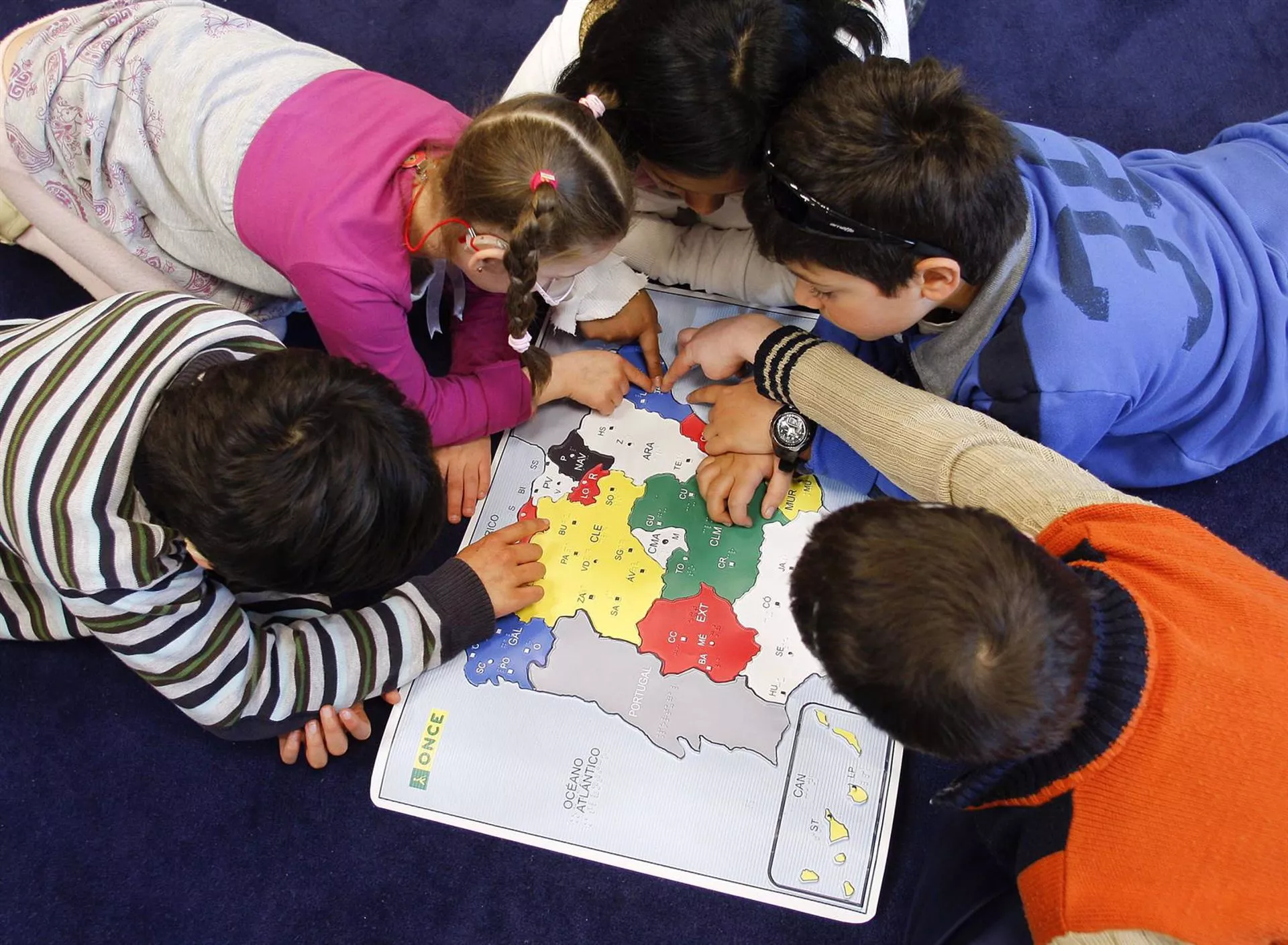 Alumnos estudiando un mapa de España