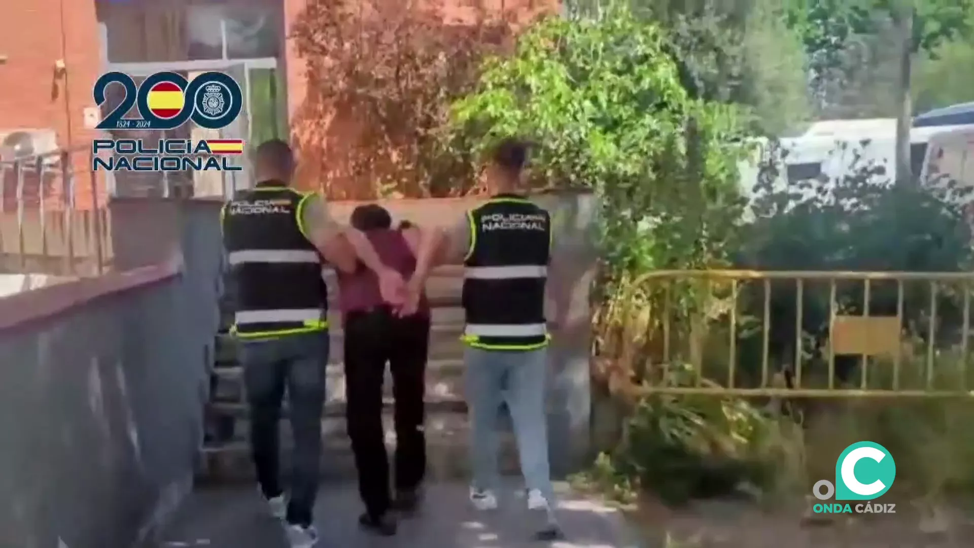 Momento del traslado de uno de los arrestados durante el operativo