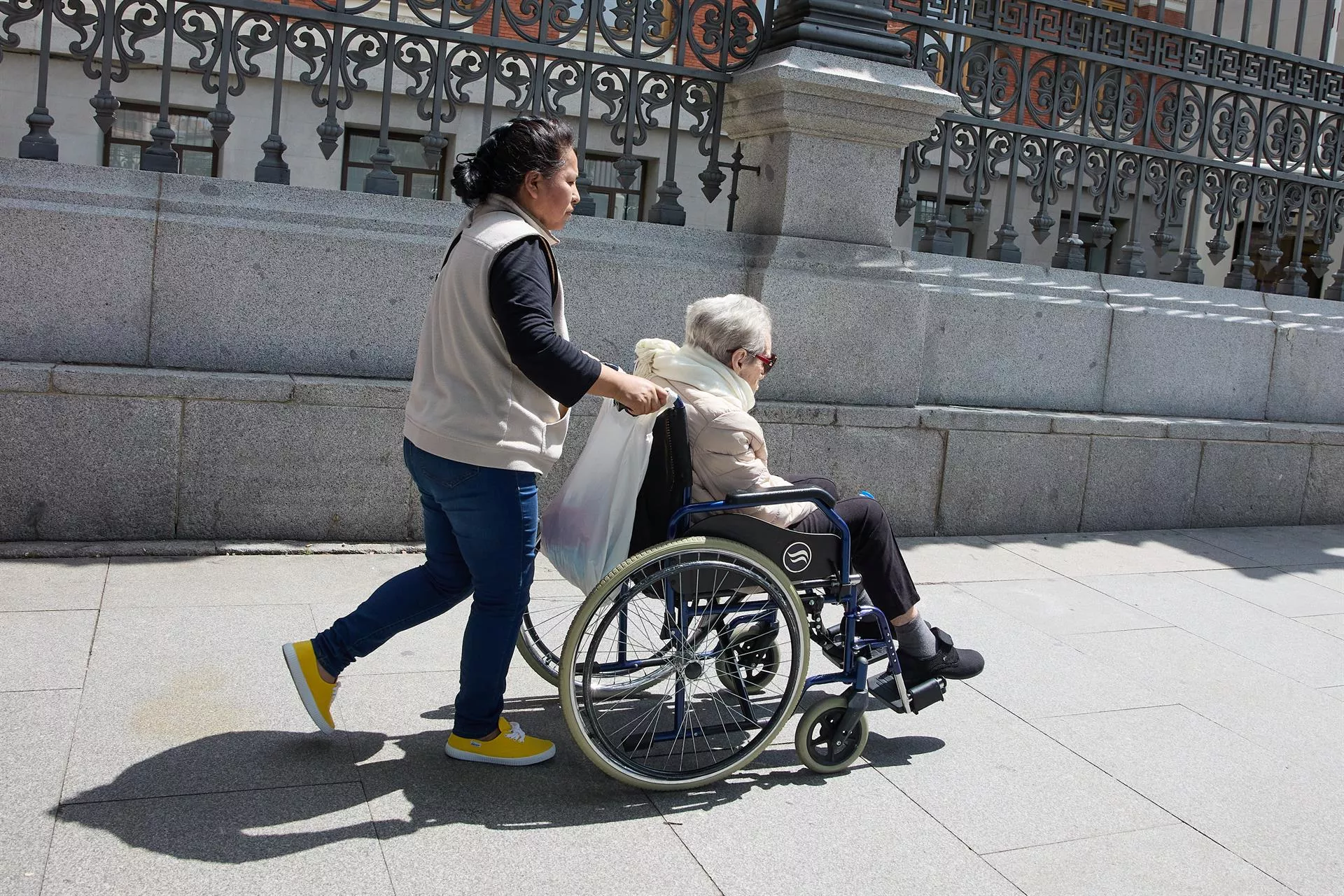  Una mujer mayor en silla de ruedas y su cuidadora 