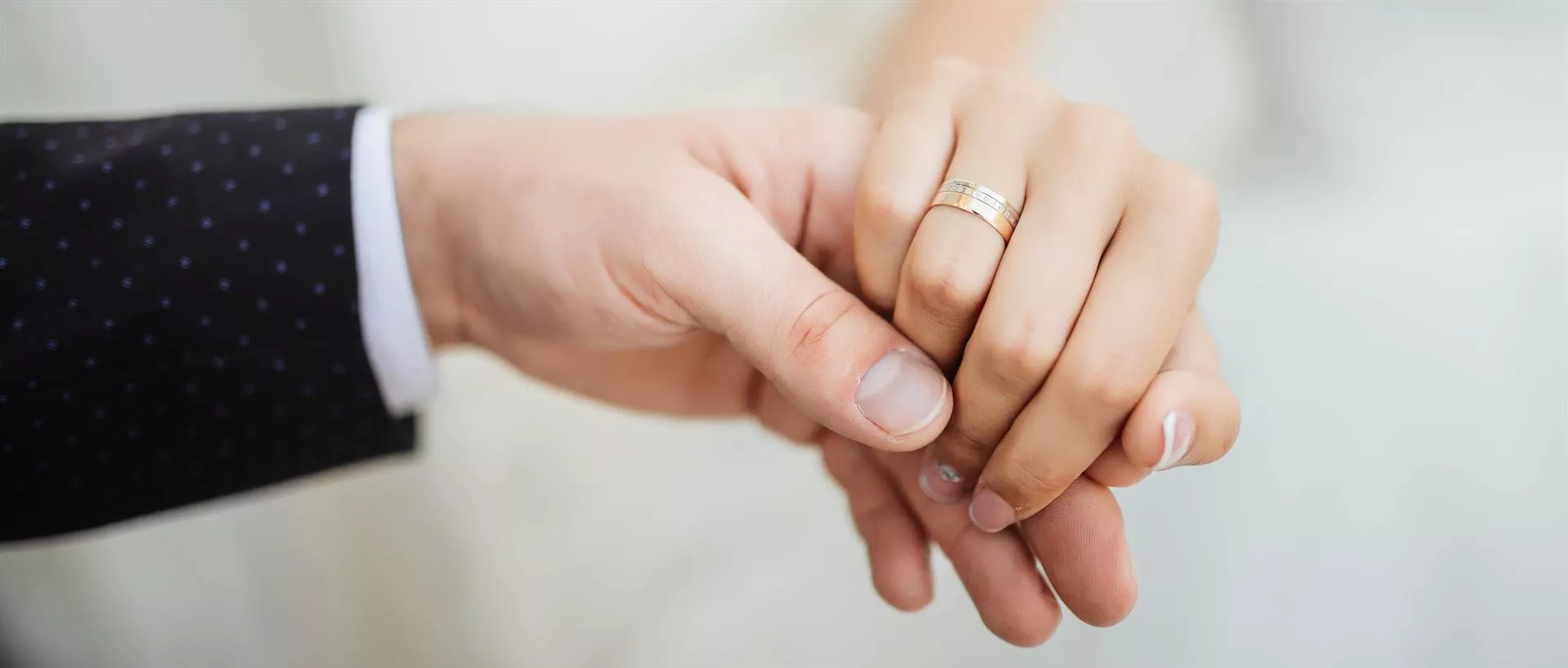 Una pareja cogida de la mano en su boda